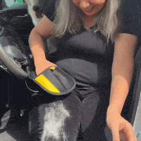 A lady removing dog hairs from her leggings using FurMate hair removal glove effortlessly 